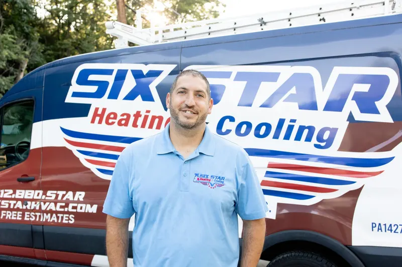 AJ Laugelli, founder of Six Star Heating & Cooling, in front of a branded service van at the Carnegie shop.